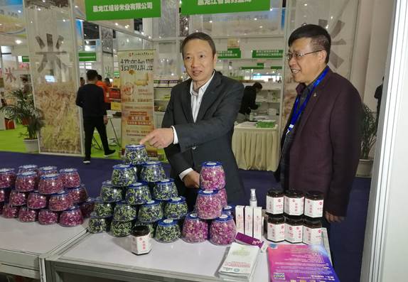 省委臺辦主任周敏謙(左)在四川雙龍農牧開(kāi)發(fā)有限公司展臺與臺商林云飛(右)親切交流
